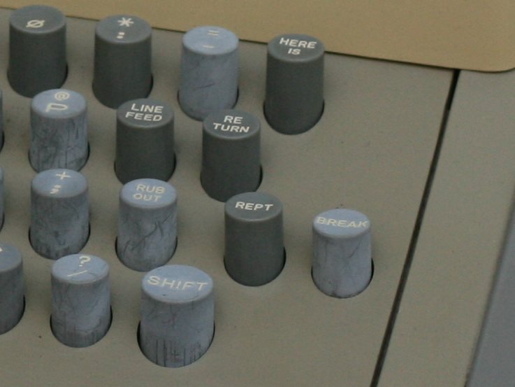 Close-up of an ASR-33 Teletype keyboard showing round keys including REPT, BREAK and RETURN.